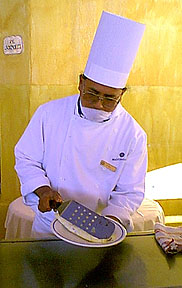 Chef at Melia Cabo San Lucas Resort Hotel prepares an omelette for breakfast wearing a mask as required by law